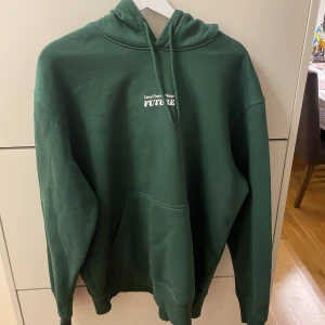 Grön hoodie med tryck - Jättefin mörkgrön hoodie ifrån hm, med tryck på både rygg och bröst. Jättebra skick, inga tecken på skador. Relaxed fit. 