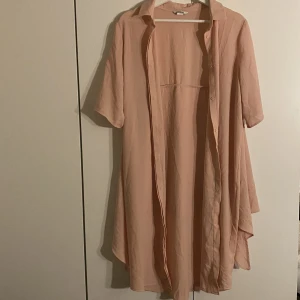 Kofta - Lång ljusrosa kofta i storlek S. Knappar framtill.