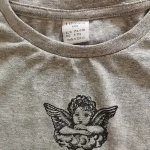 Grå T shirt med tryck jättesöt för barn funkar även som babytee för ungdomar. Använd men i god skick  Storlek: 134/140