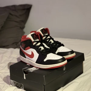 Jordan 1 Mid Gym Red - Jag säljer dessa skor då jag tänkt att köpa nya. Jag skulle säga att skicket är typ 8/10. Det enda är att sulorna är lite slitna och plast grejen på ena snöret är sönder, annars är dom i väldigt bra skick. Skriv privat för fler bilder. Box finns!