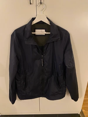 Calvin Klein jacka - Jag säljer en mörkblå tunn Calvin Klein jacka i storlek M (herr) ( väldigt bra skick) 