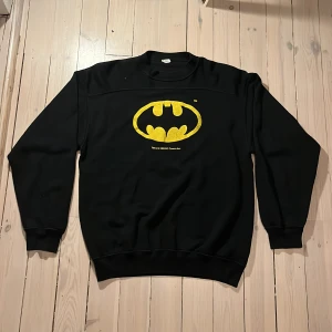  Batman sweatshirt - Tja! Säljer nu denna batman tröja som är i bra skick, tröjan är ganska gammal vet inte om den är från 1989 men det står det på den, tröjan sitter mer som Medium. Hoppas du vill köpa!