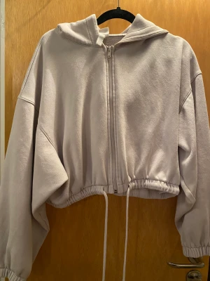 Munkjacka - Kort enkel munkjacka med resår i midjan och längst ut på ärmarna.