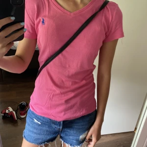 Ralph Lauren T-shirt  - En rosa v-ringad Polo Ralph Lauren T-shirt. Bra skick, säljer endast för 80kr