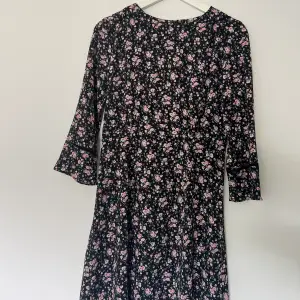svart klänning med rosa blommor från HM, använd enbart ett fåtal gånger. passar strlk xs/s 🤍