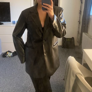 Skinnblazer - En svart skinnblazer från nakd säljes, endast använd en gång. I storlek M med oversized passform och axelvaddar. 