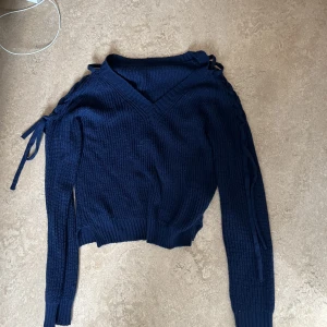 Stickad tröja - Fin marinblå stickad tröja med knytningar på sidan!