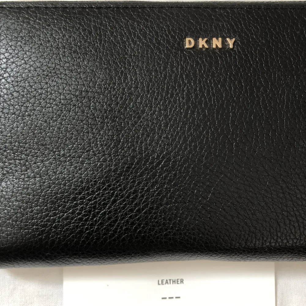 DKNY - plånbok  Svart läder och tyg.  Guld detaljer  Knappt använd, nyskick.   . Väskor.