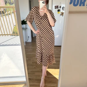 Rutig långklänning från Monki 🤎 - Brun och vit-rutig långklänning från Monki, storlek M. Väldigt luftig och skön till sommaren🤎