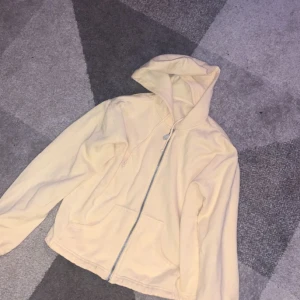 Ljusgul huvtröja. Använde massor förr men tvätta den och sedan aldrig använt mer.  - En tunn sweatshirt med dragkedja. Ljusgul. 