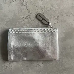 En liten silvrig plånbok som inte kommer till användning