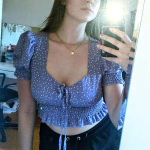 Lila blus  - Topp i tunt material vilket är skönt till sommarn. En lila prickig Crop top med puff ärmar och knytning vid brösten