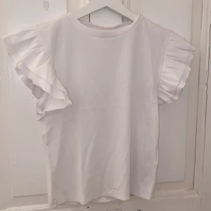 Vit tröja - Vit tröja med volanger, aldrig använd bara testad, storlek 158/164 så de är som en xs/s💓