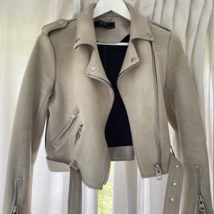 Mockajacka från Zara - Beige bikerjacka i mocka från Zara, storlek Small. I normalt skick, använts sparsamt.