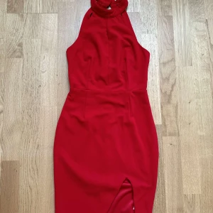 Klänning - Röd sexig klänning. Lång hals, öppning vid ena benet, kort klänning, hög kvalité, cutout rygg och halter djup urringning. Pris kan diskuteras 