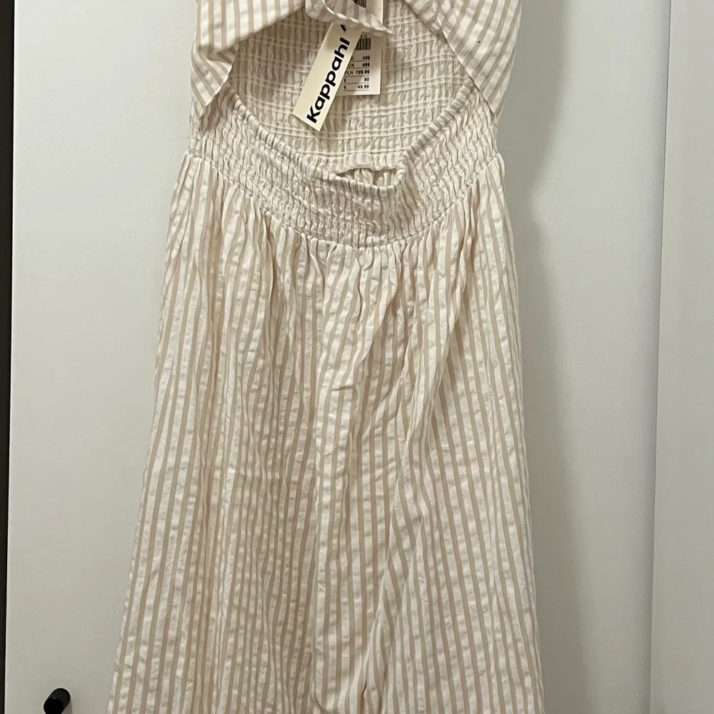 Klänning i bomull från Kappahl. Randigt mönster, knytdetalj fram och smock bak, men klänningen kan användas åt båda håll. . Klänningar.