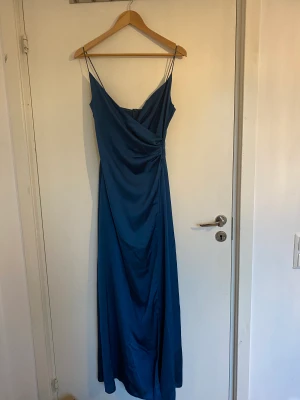 Balklänning i satin  - Fin balklänning, aldrig använd i satin. Tunna band och en slits vid benet. Dragkedja på sidan.