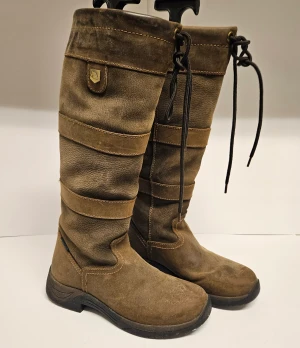 Dublin Country stävlar - Egenskaper: Vattentäta country stövlar med andasfunktion Ovandel i fullnarvsläder Fukttransporterande RCS-fotbäddssystem för komfort och andasfunktion Nylonfoder med andasfunktion.  Använda men väldigt fint skick! Storlek 37. Nypris 2399 kr.