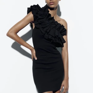 Klänning med volang - Svart kortklänning med volang över axeln, använd endast en gång