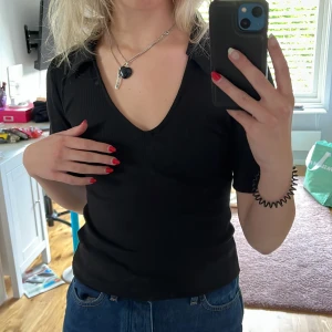 Topp bikbok - Svart V-ringad topp från bikbok med krage. Stretchigt och skönt material. Supersnygg till jeans. Säljs då den inte kommer till användning. Nyskick. Storlek: XS