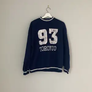 Mörkblå tjocktröja med texten Toronto 93, lite oversized