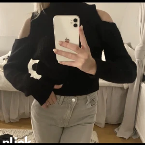Svart Långärmad topp - Stickad med hål vid axlarna som ger ett mer stiligt intryck.  Mkt fint skick