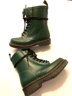 Dr Martens gummikänga stl 36 - Mörkgröna Dr Martens kängor, är som gummistövlar, helt vattentäta. Står storlek 37 men är som ett par 36. Mycket bra skick.
