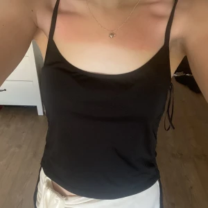 Svart linne med korsning i ryggen - Fint svart linne med korsning i ryggen från Bianca ingrossos kollektion med Gina tricot! Passar perfekt till en varm sommardag. 