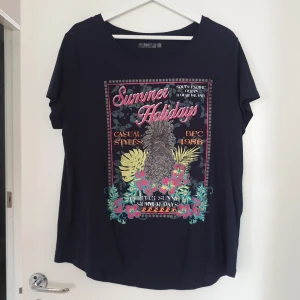 T-shirt - Oanvänd mörkblå t-shirt med tryck, 100% bomull.