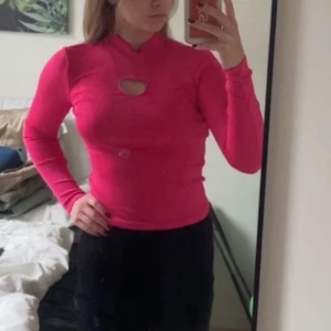 Rosa långärmad tröja  - Rosa långärmad tröja från Monki med utskuret hjärta i storlek XS som aldrig är använd så lappen sitter kvar. 
