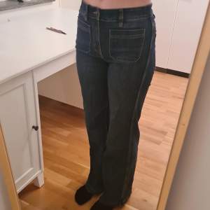 Mid-waisted jeans i storlek 36. Mörkblåa med bruna sömmar. Bra längd för någon som är lite över 170cm lång. Använd ett fåtal gånger och i väldigt bra skick.