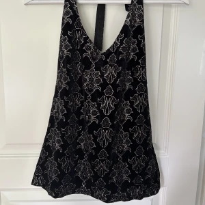 Festtopp - Jättesnygg svart fesstopp med guld/silverdetaljer och halterneck från lindex🙌🏻superfint öppen i ryggen! strl s/36