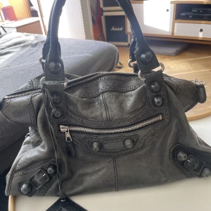 Balenciagaväska - Balenciagaväska i använt men fint skick. Har tyvärr ej de långa bandet eller dustbag.Äkthetsintyg från Vesitiare finns.OBSERVERA att ja flyttar utomlands fredag 1/9 så möts fram tills dess, annars gäller frakt från Frankrike. Gå ner i pris vid snabb affär