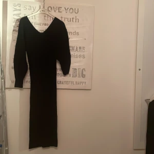 Stickad klänning  - Svart stickad klänning med ballongärmar 