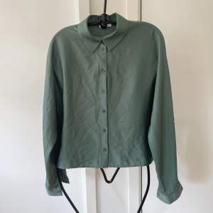 En grön fin skjorta/blus i stiligt material. 