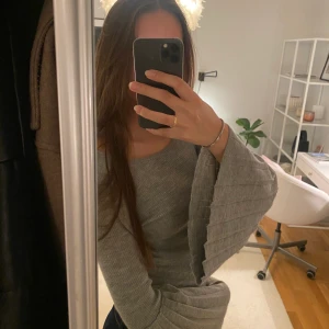 Grå tröja  - Grå ribbad tröja från Lindex med volanger vid ärmarna. Tunt material. Mycket bra skick 