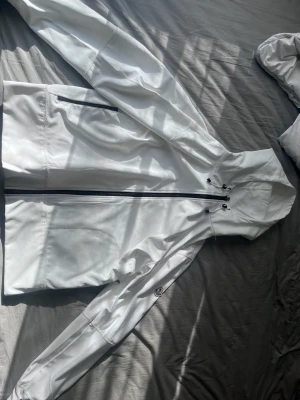Moncler jacka - Moncler jacka  En vit moncler jacka i perfekt kondition Det är en tunnare jacka då man kan använda den till sommaren/våren och hösten 