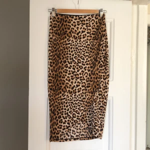 Pennkjol i djurmönster - Omlott kjol i pennmodell med resår i midjan. Trikå i 95% Polyester och 5% Elastan. 72 cm lång bak.