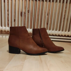 Enkla vackra stövlar med liten klack. - Bruna hala stövlar med dragkedja i sidan och liten klack.  Skorna är lite använda men i bra skick.  Jag svär att de är super bekväma.