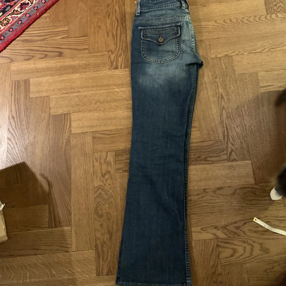 Lågmidjade utsvängda jeans från Calvin Klein. De har jättecoola bakfickor o även coola knappar där fram💕innerbenslängden är 82cm och midjan är 39cm. De passar bra i längden för mig som är 173 :) skriv vid frågor eller fler bilder . Jeans & Byxor.