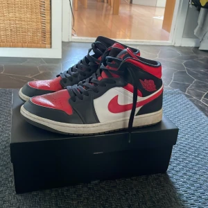 Jordan 1 mid - Säljer mina jordan 1 mid black fire red. Storlek 45 och är i 8/10 skick. Skulle även tänka mig att byta. Det ända dåliga är skosnöret på vänstra skon är sönder på änden. Ny pris runt 2000