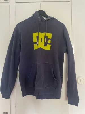 Hoodie - As cool mörklblå hoodie med neongrönt tryck. I storlek M