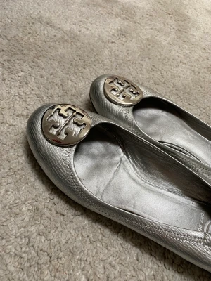 Tory Burch ballerinaskor  - Fina Tory Burch ballerinas! Passar perfekt till balen eller festen! Lite slitna på ena tån, pris kan diskuteras🙌