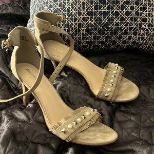 Klack skor  - Ett par beiga klack skor, väl använda men i ett bra skick. 