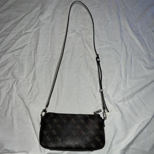 Guess väska - En super elegant Guess axelremsväska, använts en del men är fortfarande i mycket bra skick ( inga defekter som syns ) vid frågor kontakta mig och priset går att diskutera 🤍