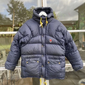 Fjällräven Expedition Vinterjacka - Hej, säljer min väldigt populära marinblå Fjällräven vinterjacka i bra skick. Storlek XXXS men kan passa allt från 160-180 cm beroende på storleksperferens. Finns en liten defekt, bild i DM. Nypris över 7000kr. Pris kan diskuteras. Hör av dig vid frågor. 