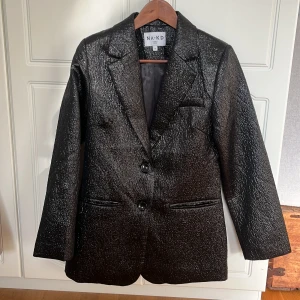 Kavaj Nakd - Ball blazer från Na-kd i skimrande svart. Använd 1 gång och i väldigt gott skick. Storlek 34, sitter perfekt oversized