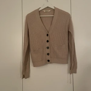 Stickad cardigan - Super fin cardigan i ljusrosa/gammalrosa, bra skick utöver armarnas uppsprättningar!