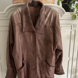 Brun läderkappa - Italienskt läderkappa i brun. Lite missfärgat på axlarna men inget som märks. Snygg oversized