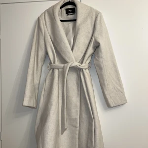 Kappa Bikbok - Ullblandad beige/vit kappa från Bikbok, strl medium. i nyskick då den endast är provad. Köpt för 899:-